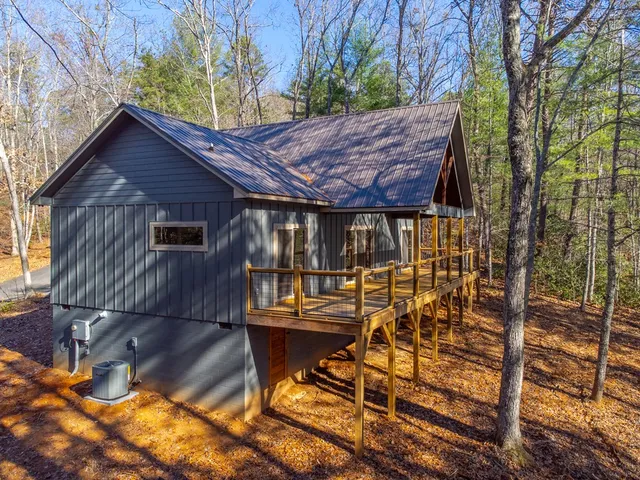 a view of a backyard with table and chairs with wooden floor and fence