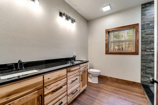 a bathroom with a granite countertop sink a toilet and a mirror