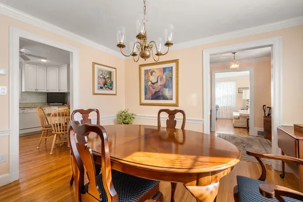 a dining room with furniture a chandelier and wooden floor