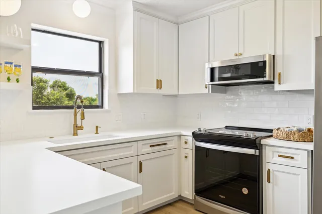 a kitchen with stainless steel appliances white cabinets and a sink