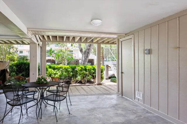 a view of a porch with chairs and plants