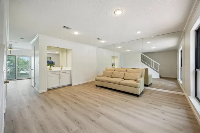 a living room with furniture and view of kitchen