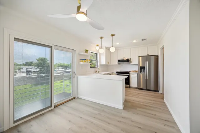 a kitchen with kitchen island wooden floors appliances and cabinets
