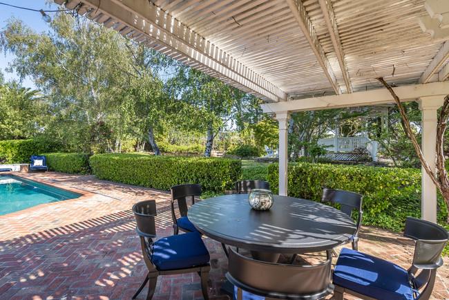 280 Ridgeway Road Woodside, CA 94062 - Photo 46 of 65 a view of a patio with table and chairs potted plants with wooden floor and fence
