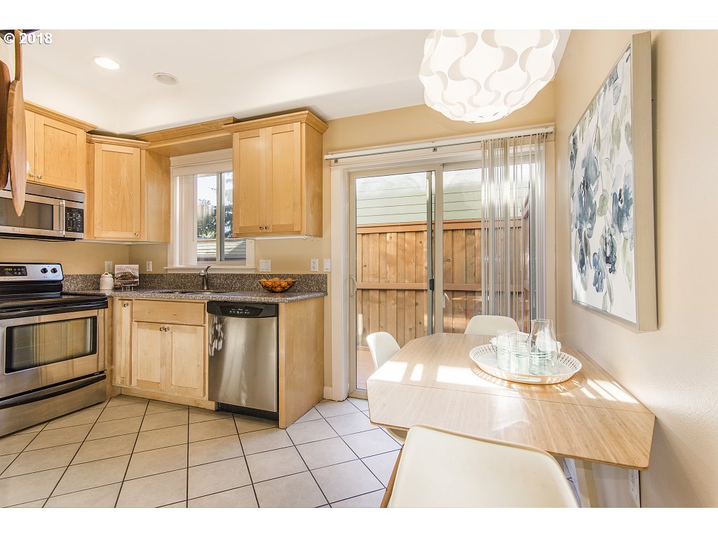 1126 Northeast 60th Avenue Portland, OR 97213 - Photo 11 of 25 a open kitchen with granite countertop a stove a sink dishwasher and a microwave