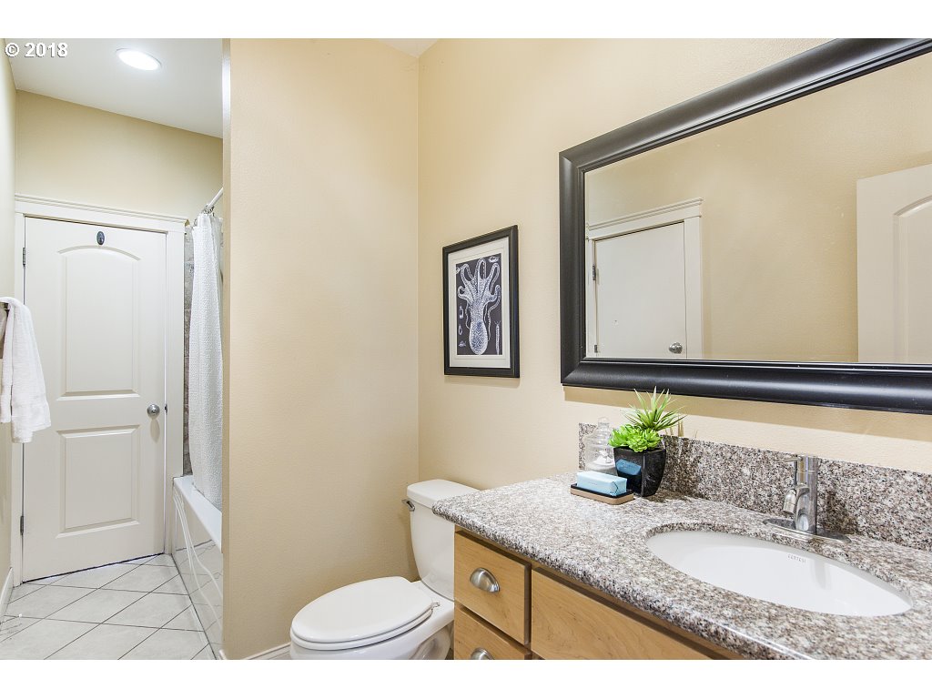 1126 Northeast 60th Avenue Portland, OR 97213 - Photo 15 of 25 a bathroom with a granite countertop sink a toilet and mirror
