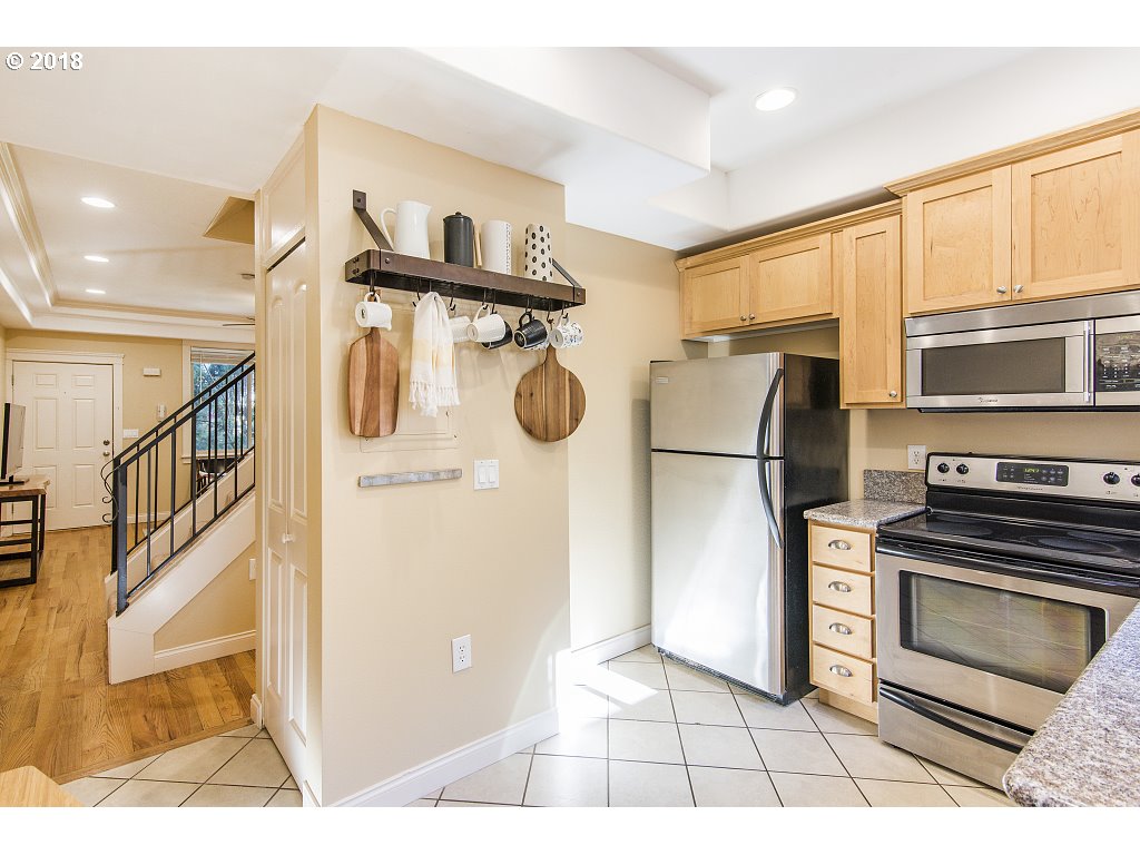 1126 Northeast 60th Avenue Portland, OR 97213 - Photo 10 of 25 a kitchen with stainless steel appliances granite countertop a refrigerator a stove and a sink with wooden floor