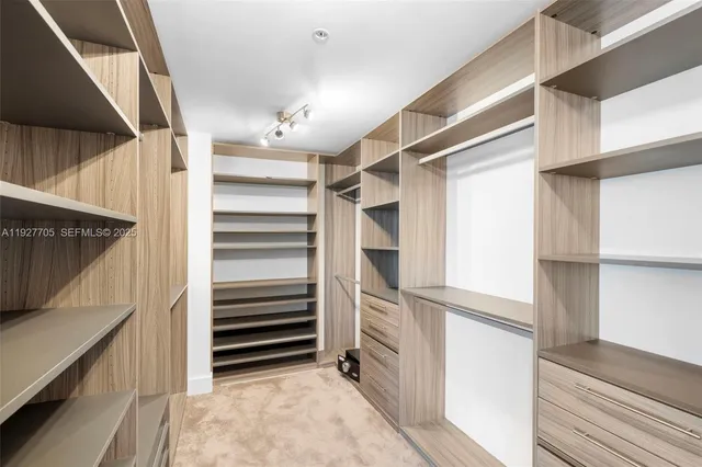 a view of walk in closet with empty racks