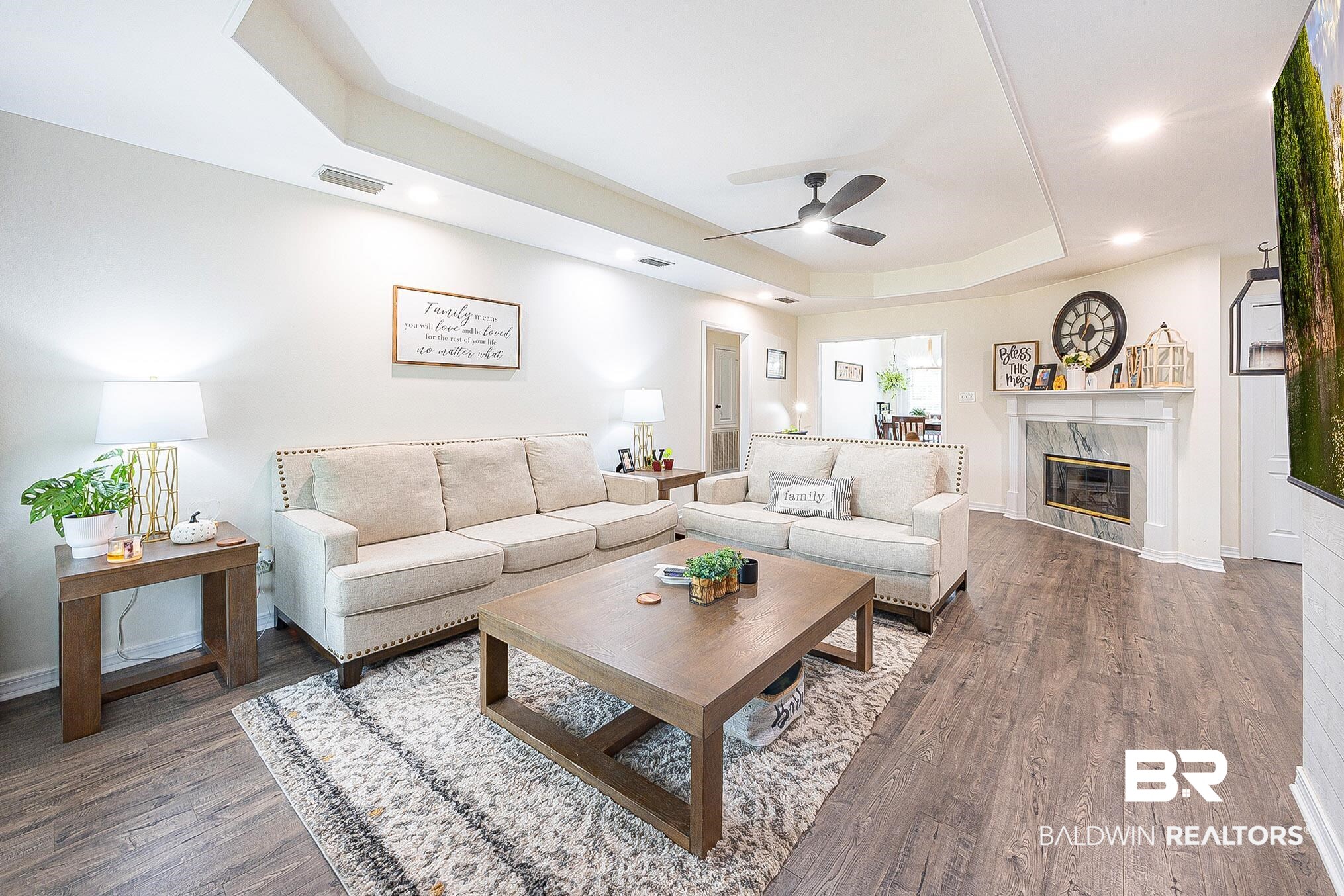 5304 Lansdowne Drive Mobile, AL 36693 - Photo 3 of 28 Living room with tray ceilings, Luxury vinyl plank flooring, new light fixtures and a wood burning fireplace.