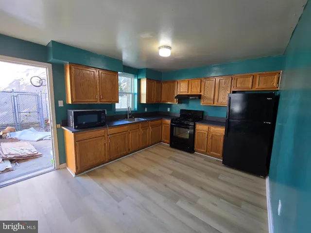 a kitchen with stainless steel appliances granite countertop a refrigerator a stove a sink and a microwave