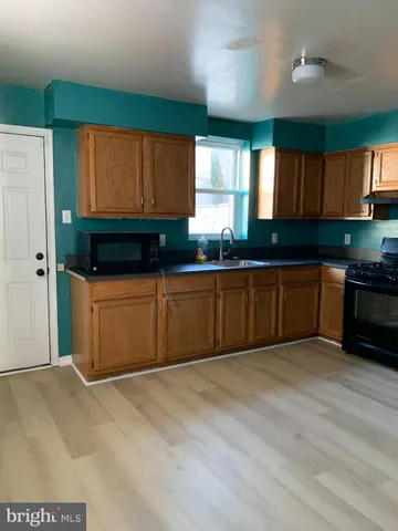 a kitchen with stainless steel appliances granite countertop a sink cabinets and wooden floor