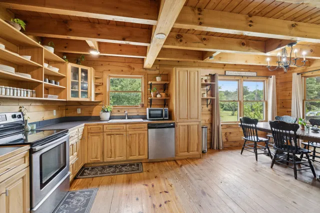 a view of a dining room with furniture large windows and wooden floor
