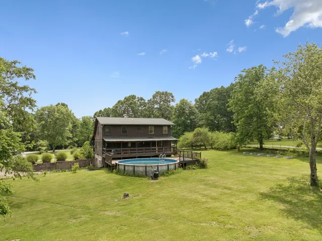 an aerial view of residential houses with outdoor space and trees