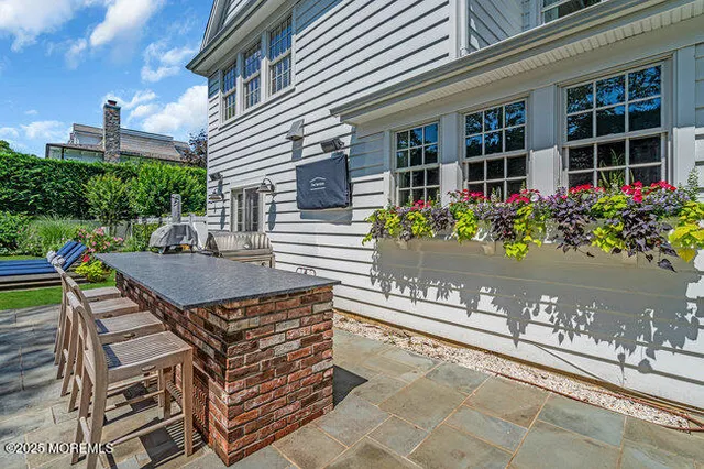 a kitchen with stainless steel appliances a stove a sink a dining table and chairs with wooden floor