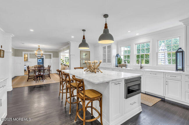 12 Red Oak Drive Spring Lake, NJ 07762 - Photo 31 of 79 a kitchen with stainless steel appliances a stove a sink a dining table and chairs with wooden floor