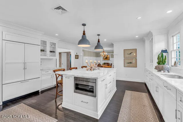 a dining room with wooden floor a chandelier a glass table and chairs