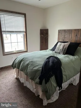 a living room with a bed furniture and a large window