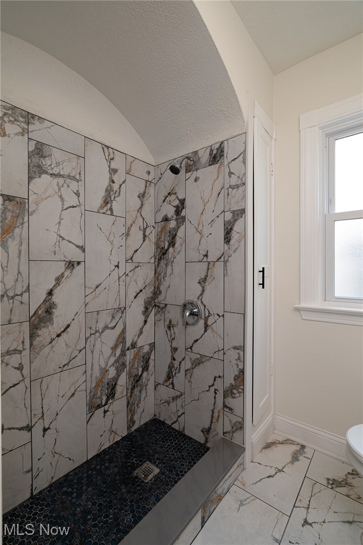 12727 Grannis Road Cleveland, OH 44125 - Photo 22 of 43 Bathroom featuring toilet, a tile shower, and tile patterned flooring