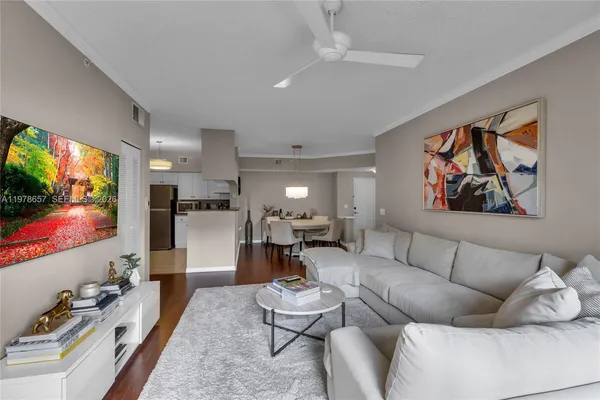 a living room with furniture a flat screen tv and a large window