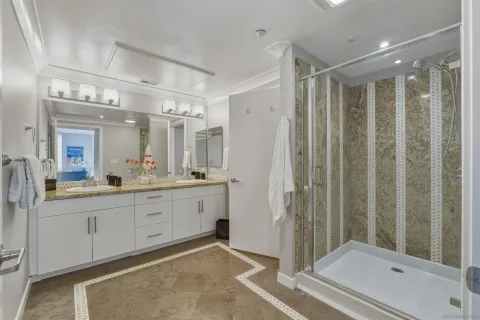 a bathroom with a mirror a double vanity sink and glass door