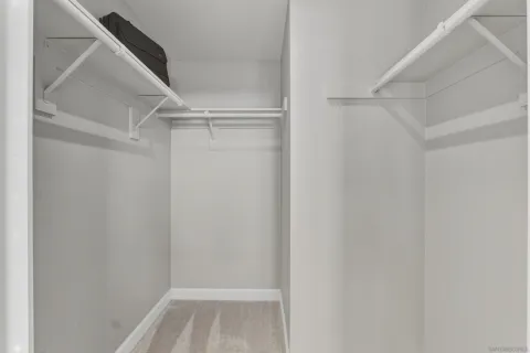 a view of walk in closet with empty racks