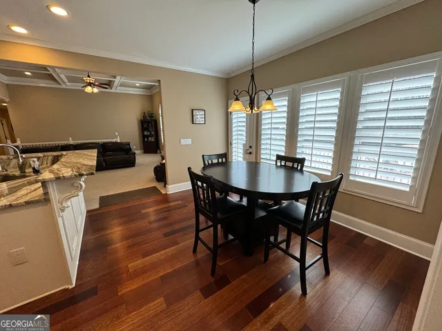 a view of living room kitchen with stainless steel appliances wooden floor and large window