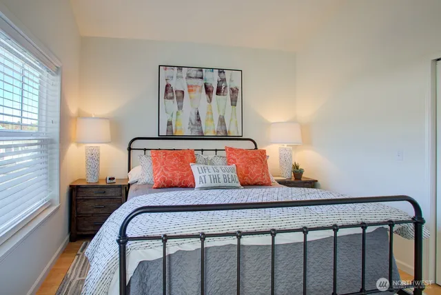 a bedroom with a bed and painting on the wall