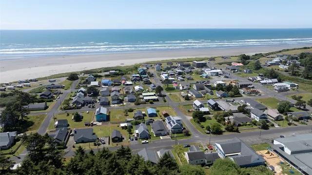 an aerial view of ocean and residential houses with outdoor space