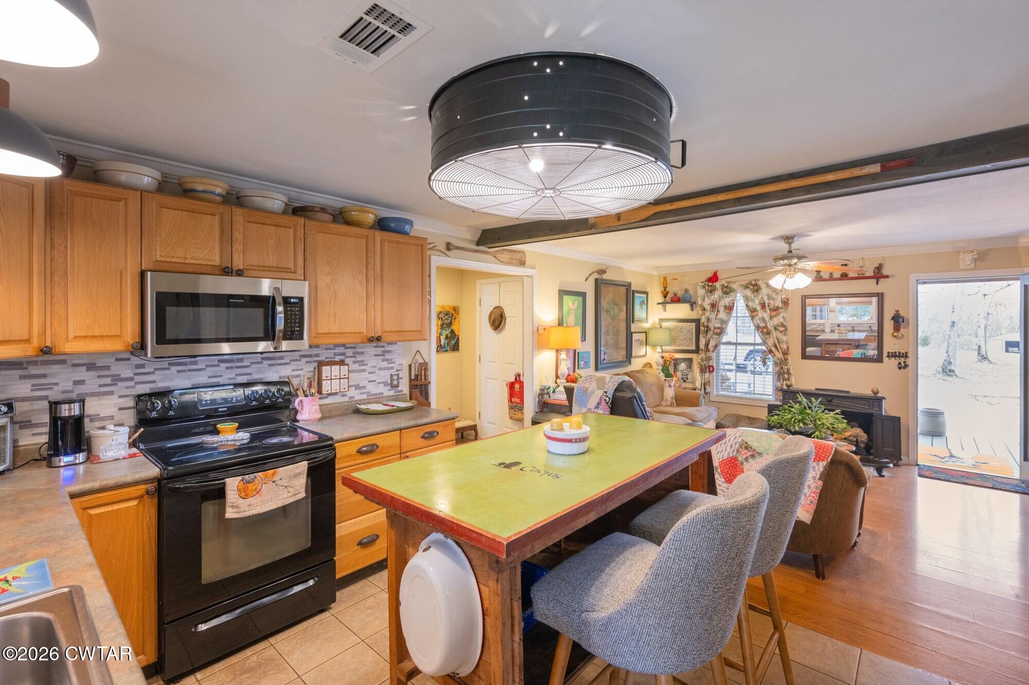 2108 Bohannon Landing Road Sugar Tree, TN 38380 - Photo 14 of 57 a view of a dining room with furniture a kitchen and chandelier