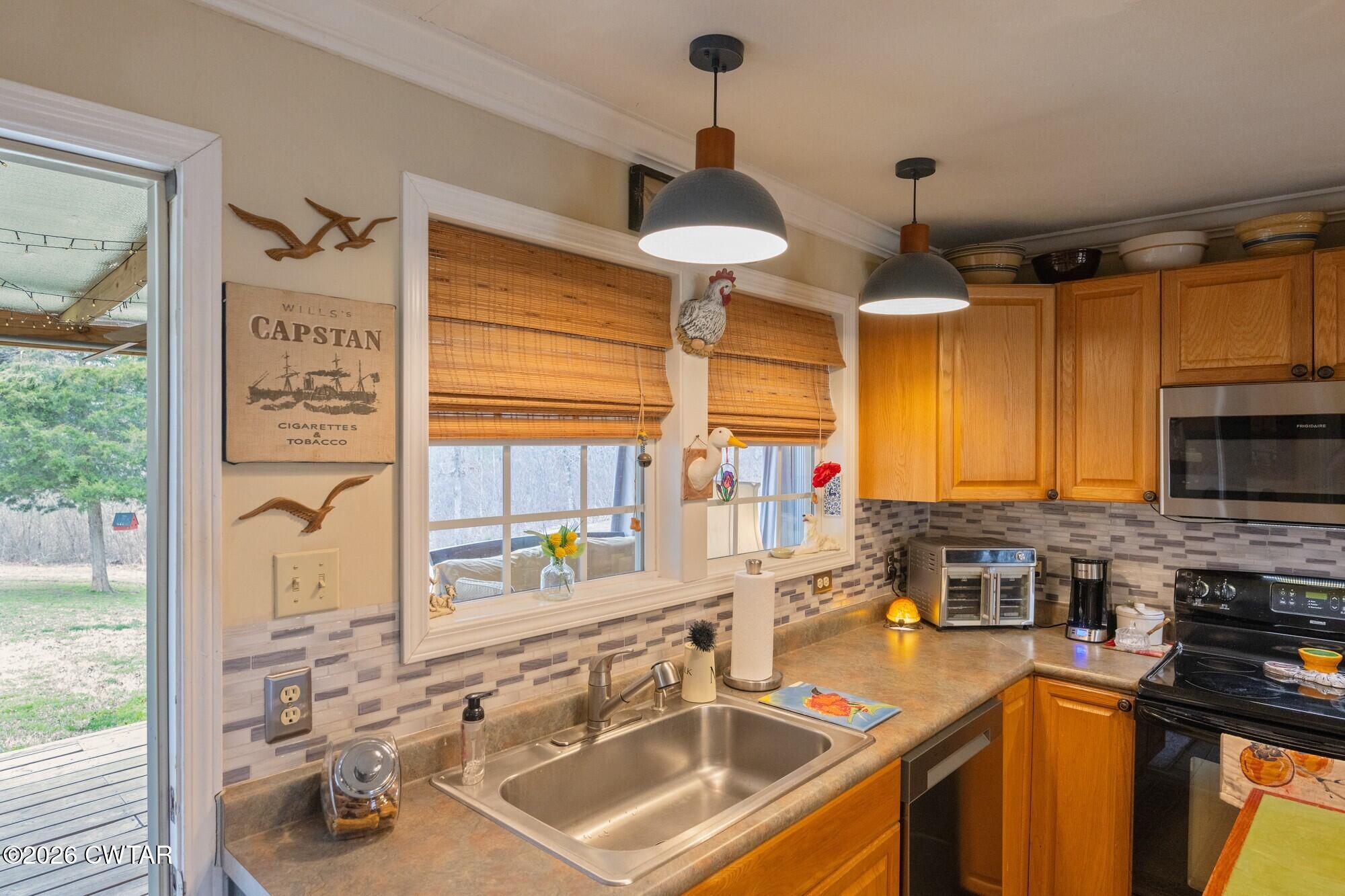 2108 Bohannon Landing Road Sugar Tree, TN 38380 - Photo 28 of 57 a kitchen with stainless steel appliances a sink a stove and a window
