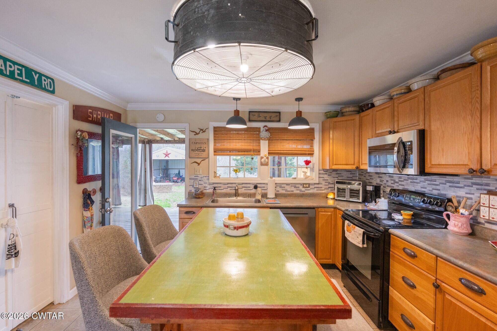 2108 Bohannon Landing Road Sugar Tree, TN 38380 - Photo 8 of 57 a room with stainless steel appliances granite countertop a kitchen island a stove a sink a dining table and chairs