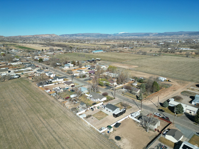 1852 East 3500th Street South Vernal, UT 84078 - Photo 34 of 46 Aerial view of property and surrounding area with rural landscape, mountains, and nearby suburban area-looking north west