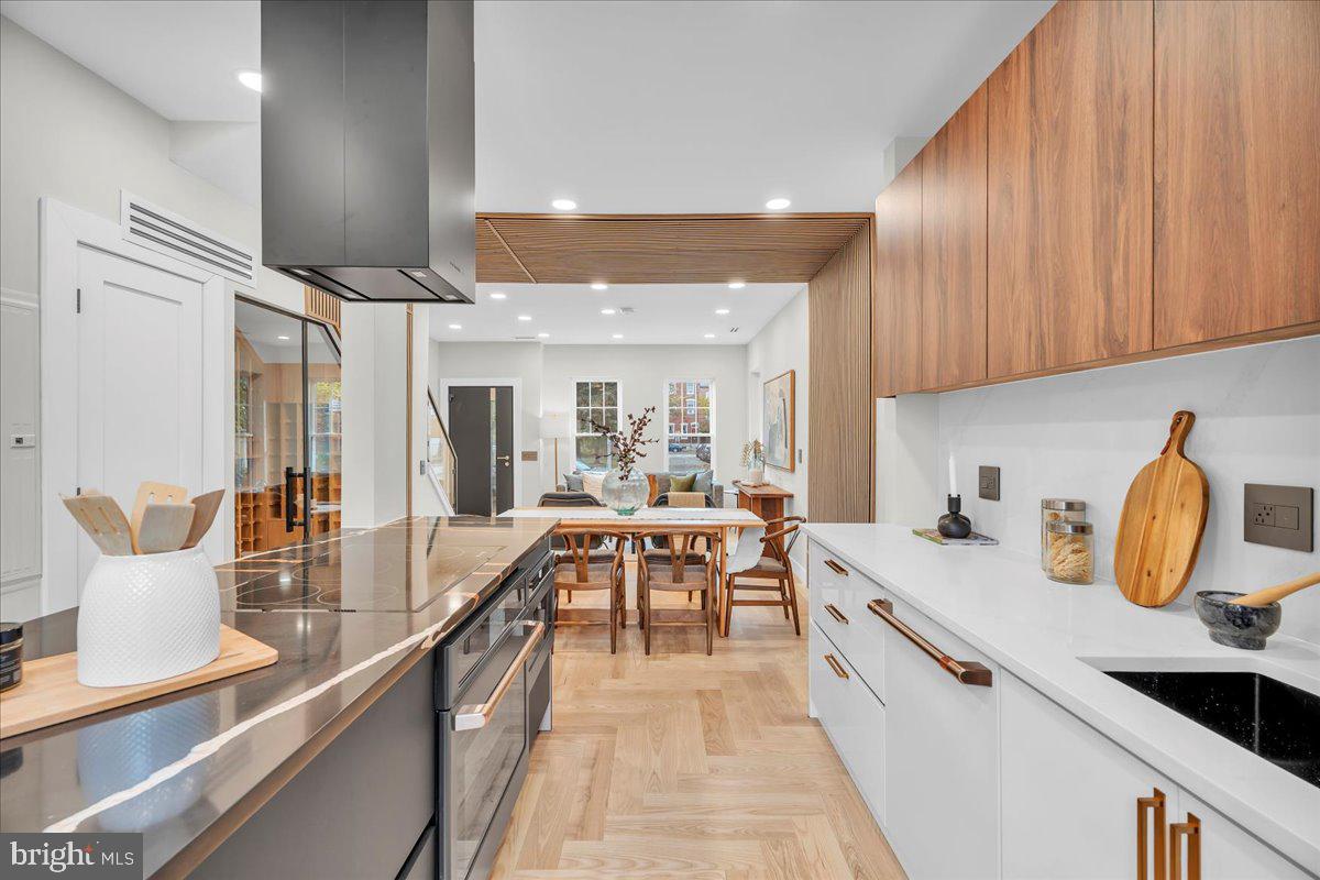 1227 Clymer Street Philadelphia, PA 19147 - Photo 13 of 37 a large kitchen with kitchen island a stove a sink a dining table and chairs