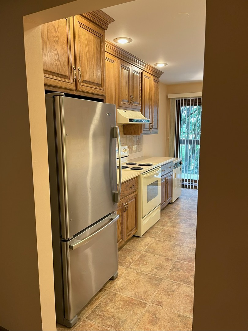 711 South River Road, Unit 401 Des Plaines, IL 60016 - Photo 13 of 22 a kitchen with stainless steel appliances granite countertop a refrigerator a stove a sink dishwasher and a refrigerator