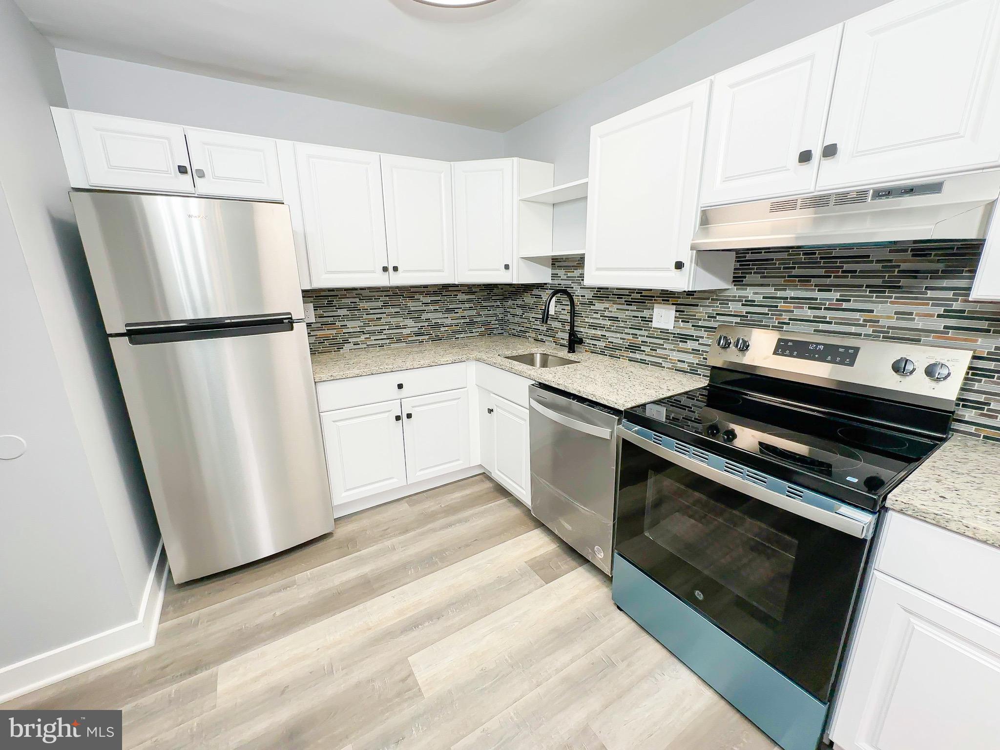 10167 Scotch Hill Drive, Unit 283 Upper Marlboro, MD 20774 - Photo 11 of 22 a kitchen with a sink a refrigerator a white and grey cabinets