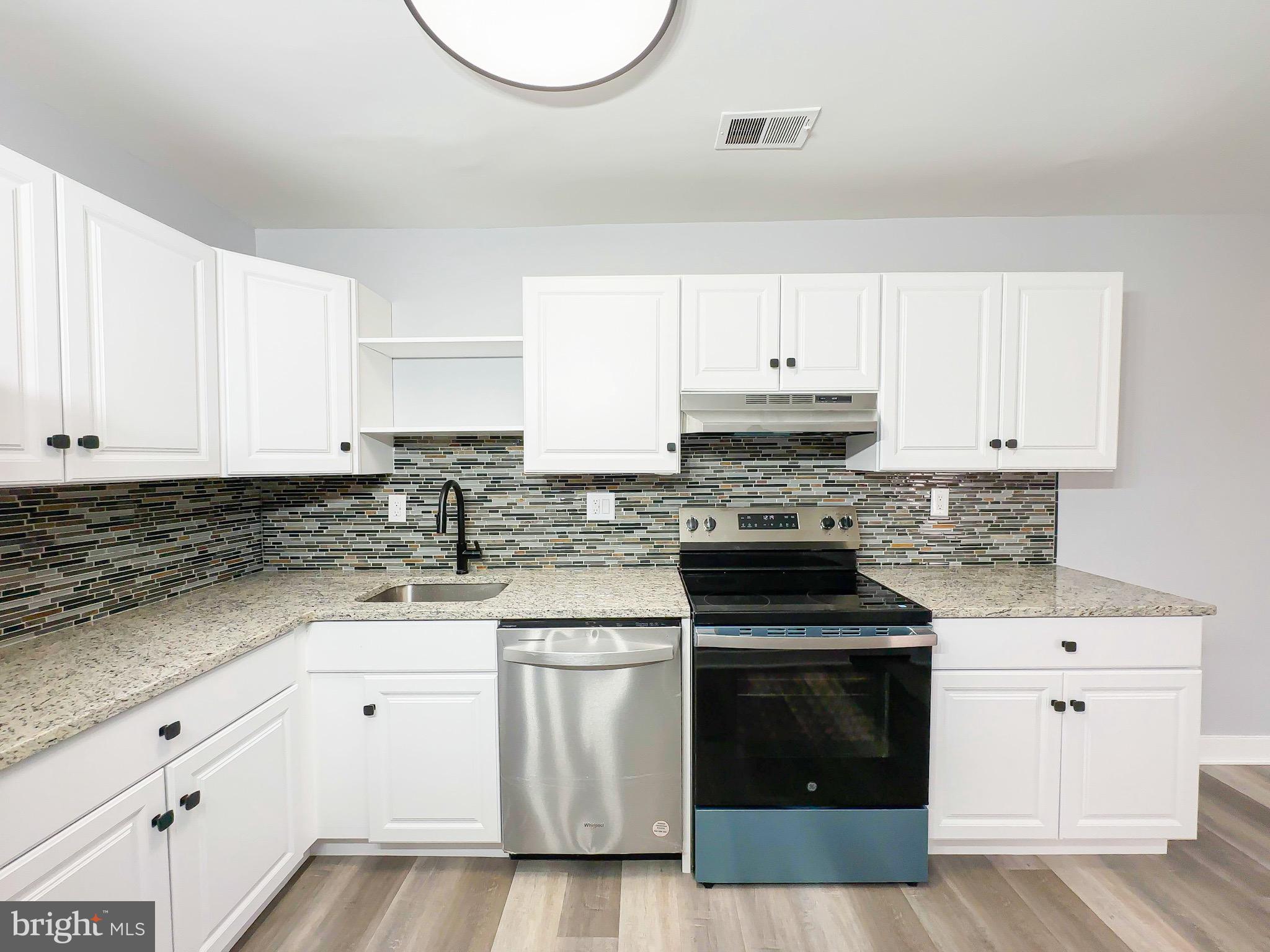 10167 Scotch Hill Drive, Unit 283 Upper Marlboro, MD 20774 - Photo 12 of 22 a kitchen with granite countertop white cabinets and stainless steel appliances