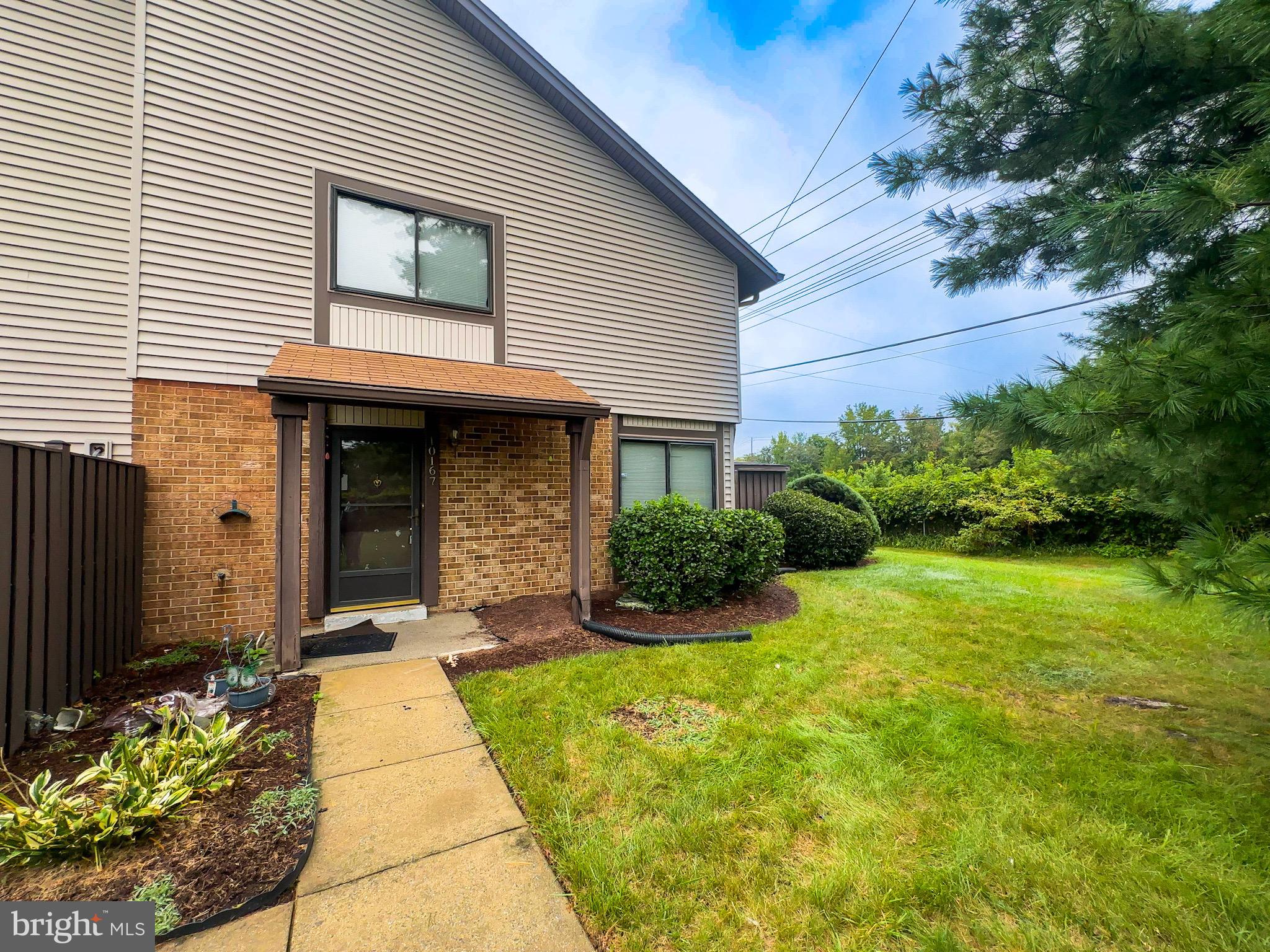 10167 Scotch Hill Drive, Unit 283 Upper Marlboro, MD 20774 - Photo 2 of 22 a view of a house with potted plants and a table and chairs