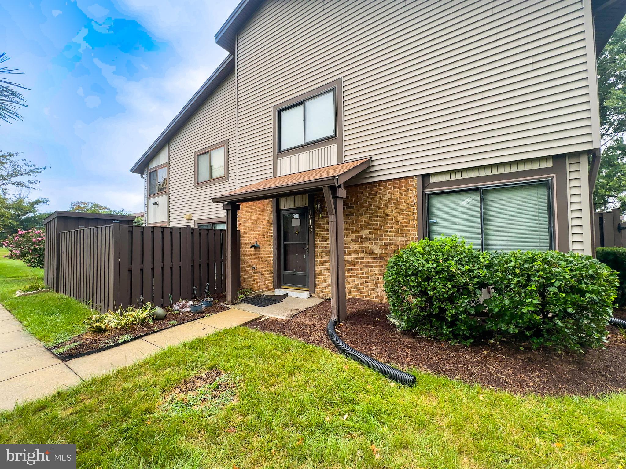 10167 Scotch Hill Drive, Unit 283 Upper Marlboro, MD 20774 - Photo 3 of 22 a view of a house with wooden fence and a large tree