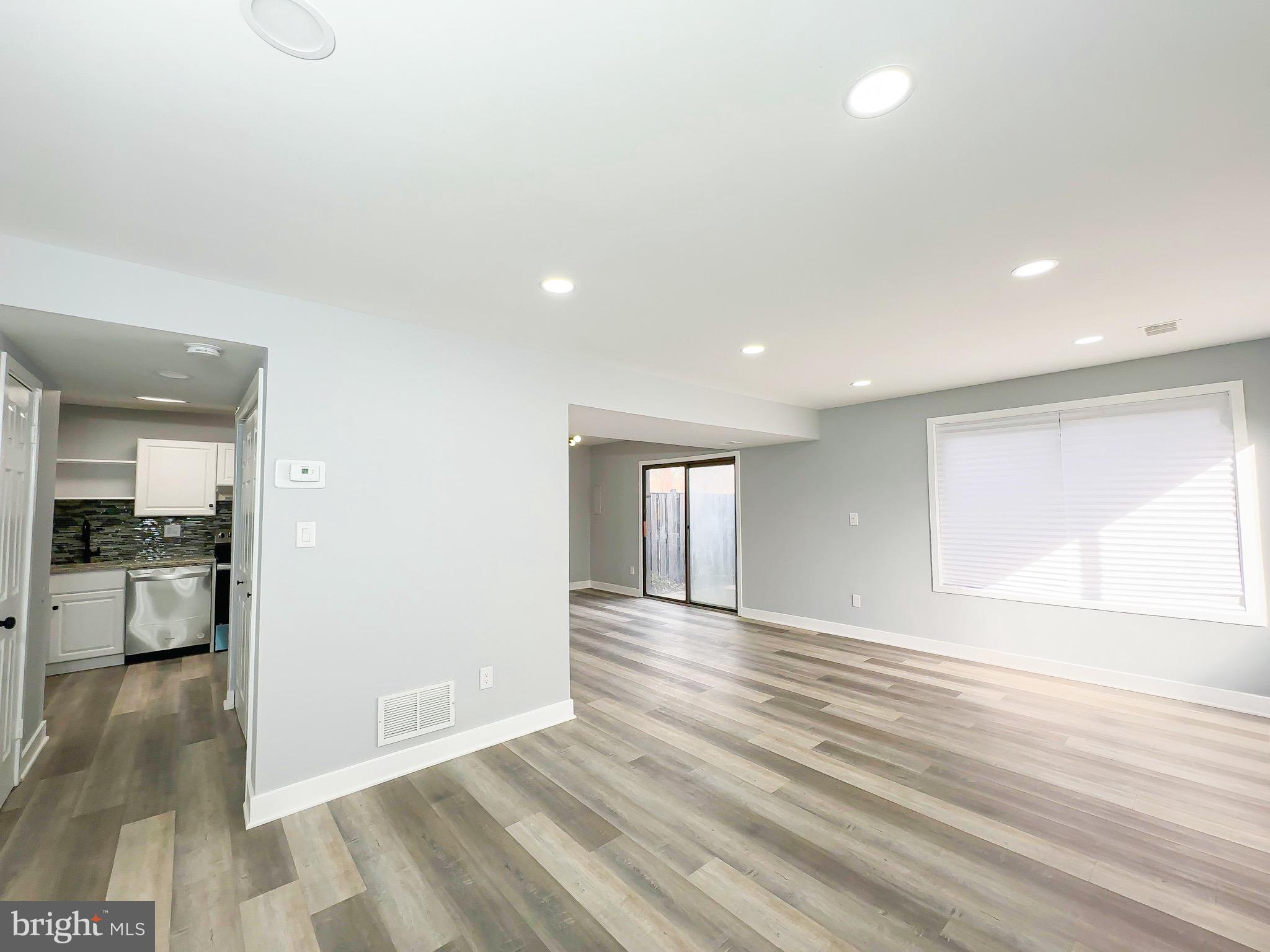 10167 Scotch Hill Drive, Unit 283 Upper Marlboro, MD 20774 - Photo 6 of 22 an empty room with wooden floor and windows