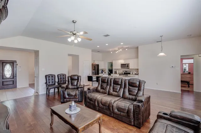 a living room with furniture kitchen view and a chandelier