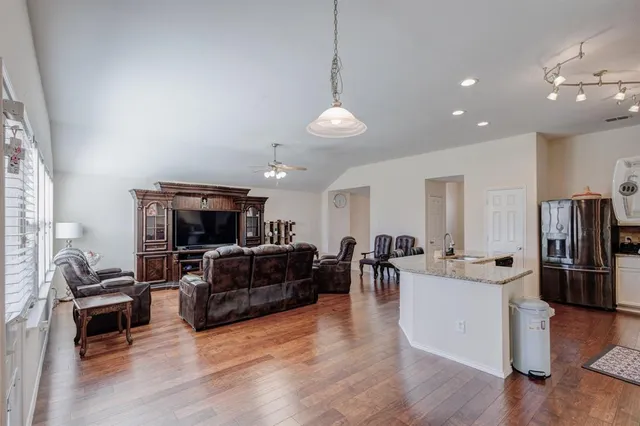 a living room with furniture a flat screen tv and kitchen view