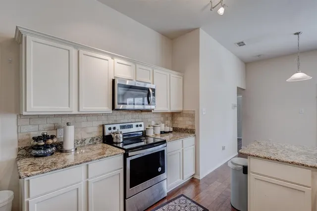 a kitchen with stainless steel appliances granite countertop a sink stove and cabinets