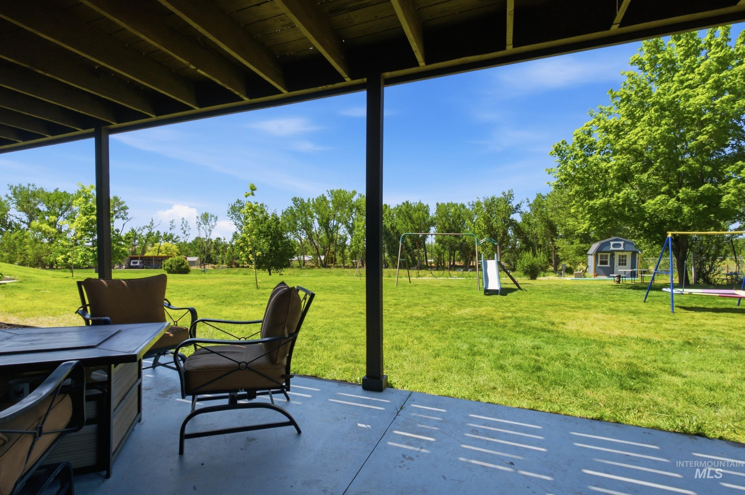 7781 Redmon Road Caldwell, ID 83607 - Photo 15 of 50 Expansive green lawn with mature trees and a swing set