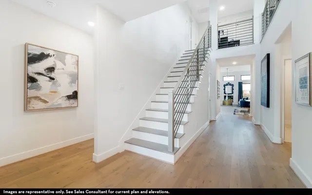 a view of a hallway with wooden floor and stairs