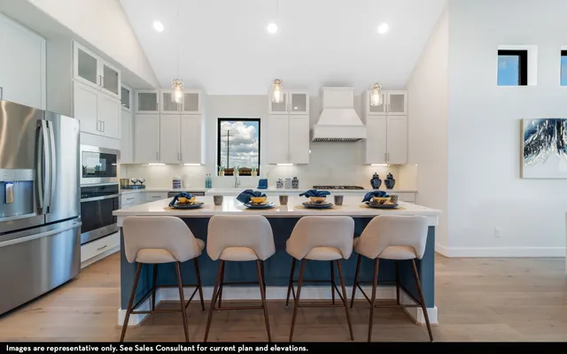 a kitchen with stainless steel appliances a dining table and chairs