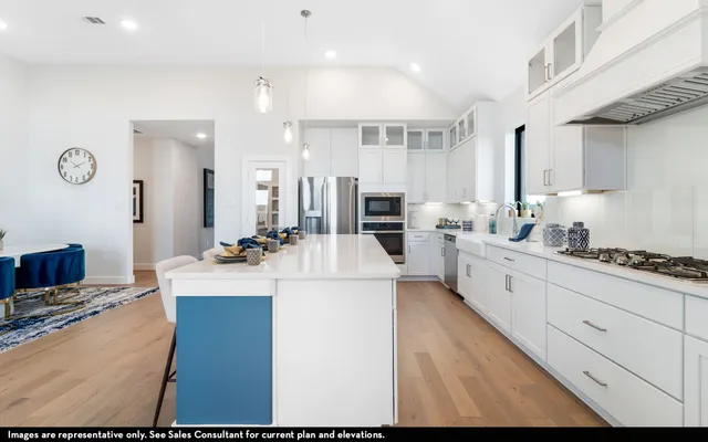 a large white kitchen with cabinets