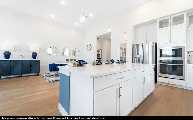 a large white kitchen with stainless steel appliances