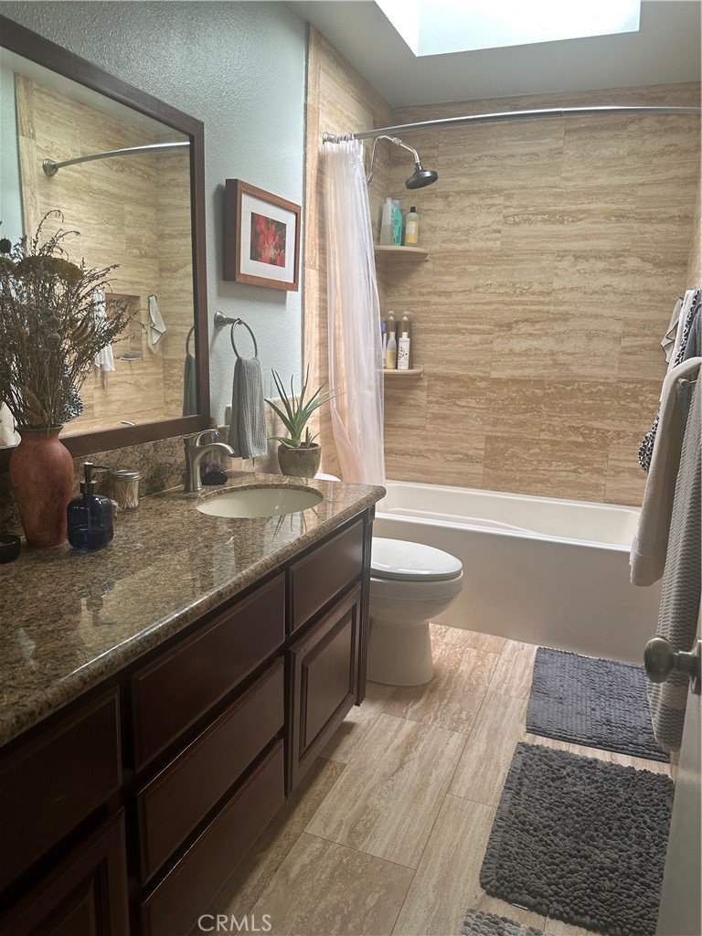 22161 James Alan Circle Chatsworth, CA 91311 - Photo 2 of 3 a bathroom with a granite countertop sink a toilet a mirror and shower
