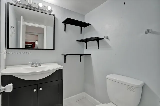 a bathroom with a toilet sink and mirror