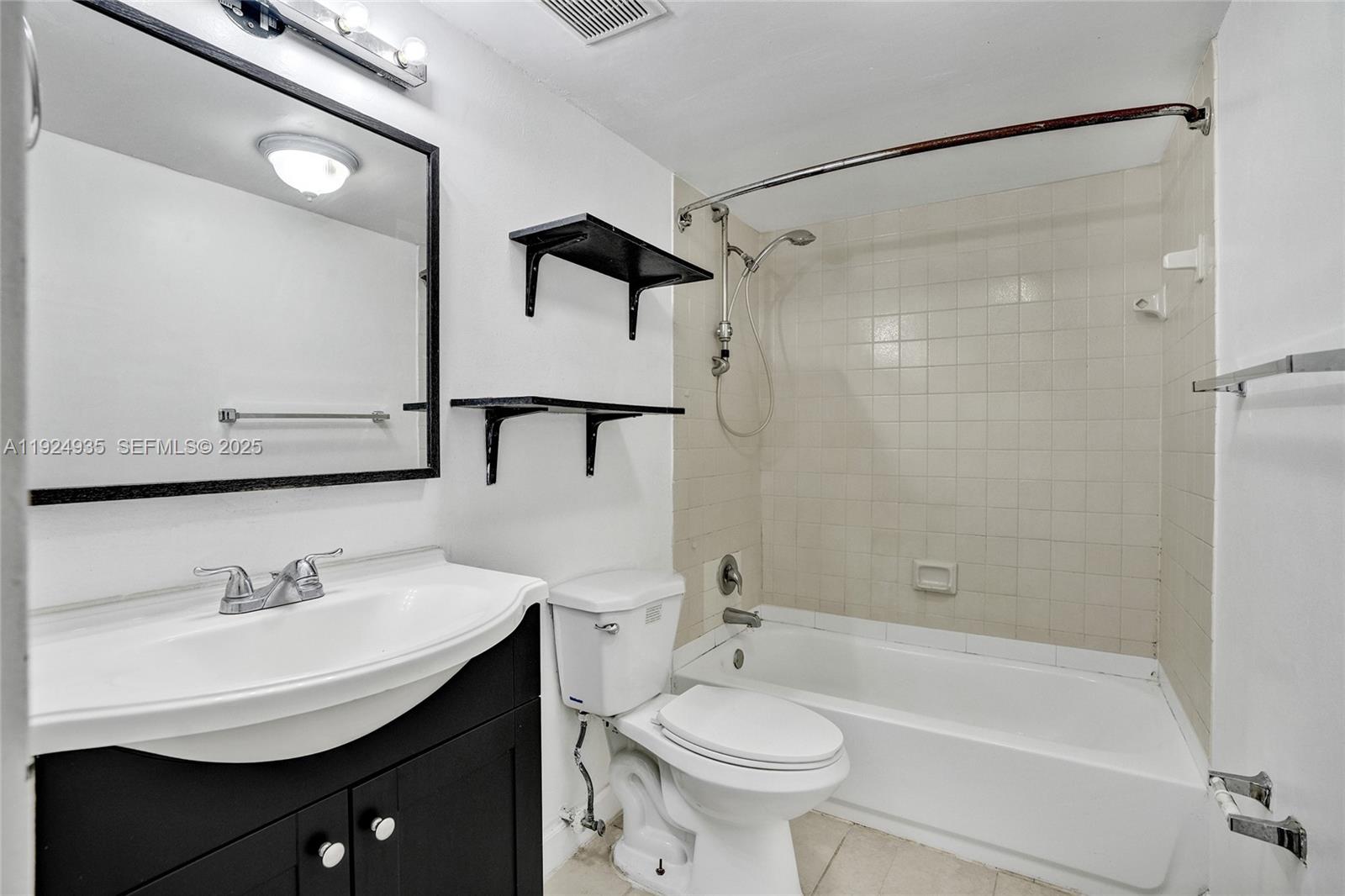 20607 Northeast 7th Court Miami, FL 33179 - Photo 35 of 49 a bathroom with a sink toilet a mirror a bathtub and shower